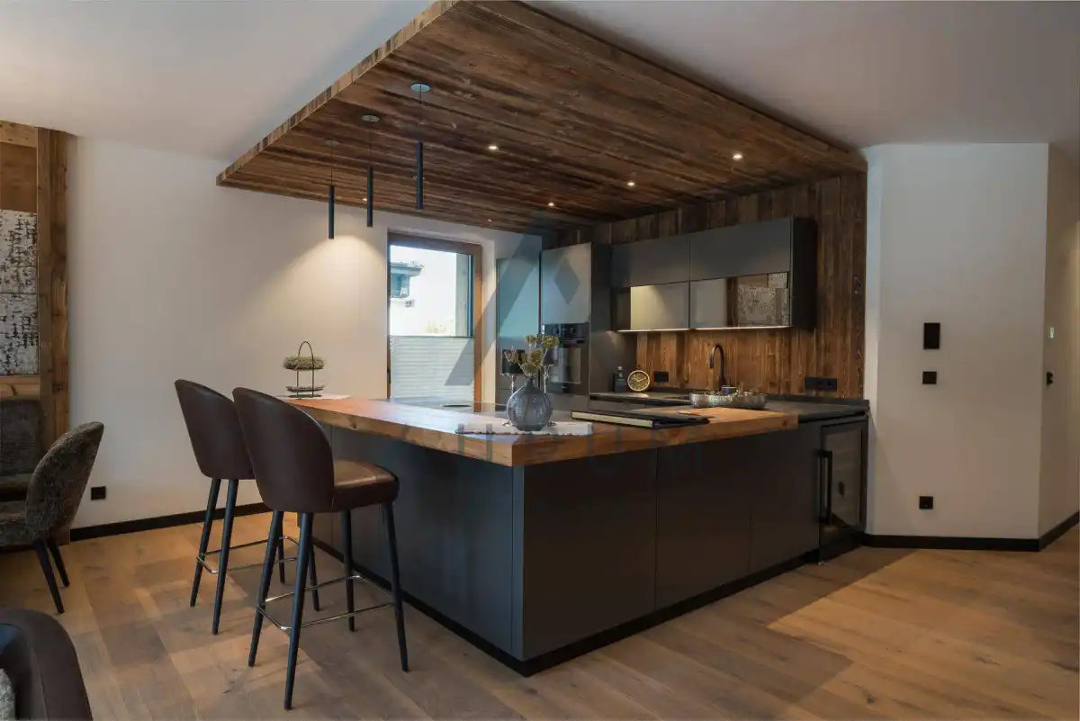 Moderne Küche mit Kücheninsel, Holzakzenten und integrierten Geräten in warmem Ambiente.