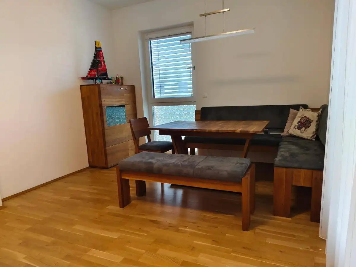 Gemütlicher Essbereich mit Holztisch, Eckbank und einem Fenster für natürliches Licht.