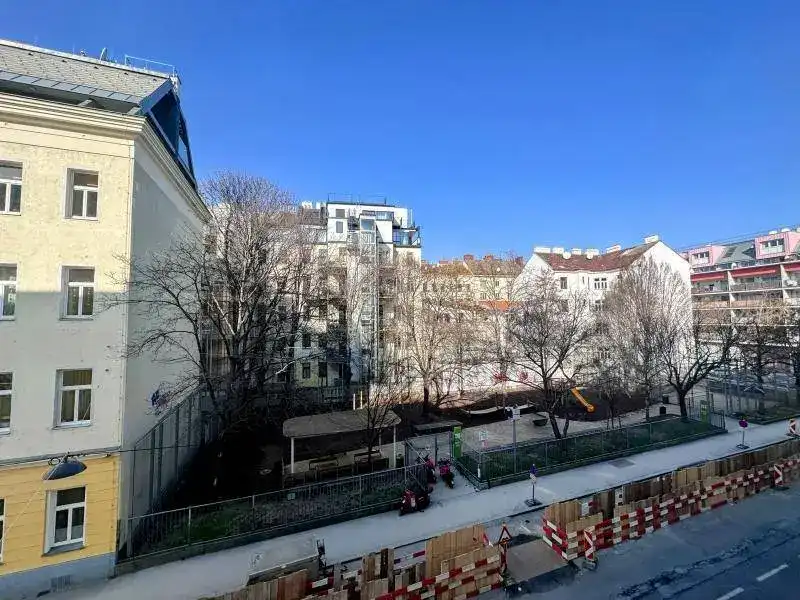 Blick auf einen städtischen Innenhof mit Spielplatz und umliegenden Gebäuden.
