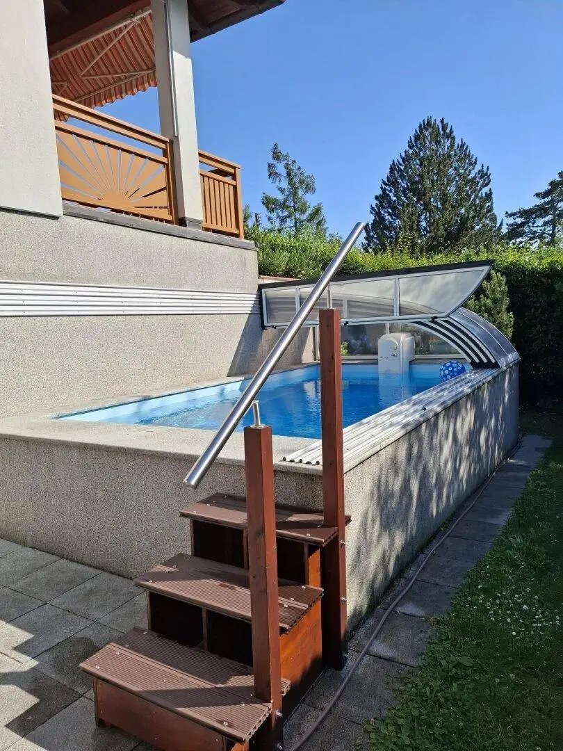 Dans l’eau fraîche : bungalow avec piscine et terrain supplémentaire à Schafberg, offrant des possibilités d’aménagement futur.