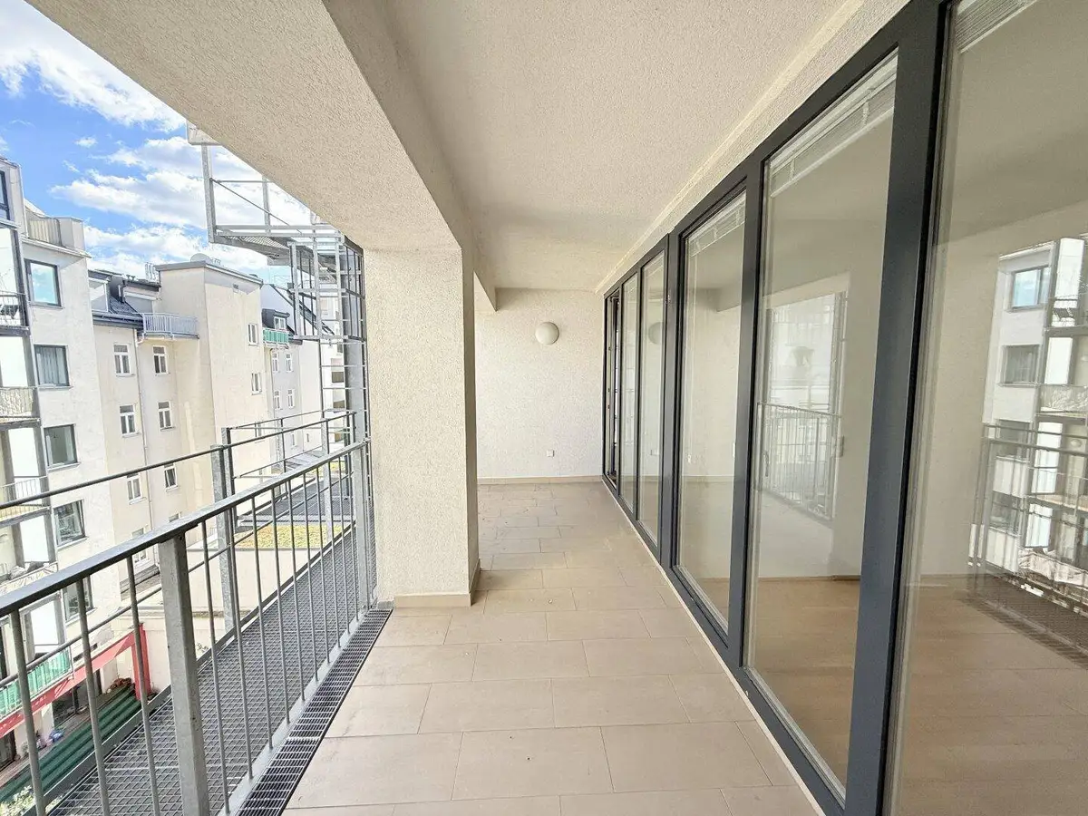 Geräumiger Balkon mit Fliesenboden und weitem Blick auf die städtische Umgebung.