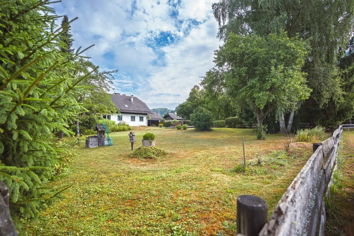 Großer Garten mit Rasenfläche, altem Baumbestand und Blick auf das charmante Wohnhaus im Grünen.