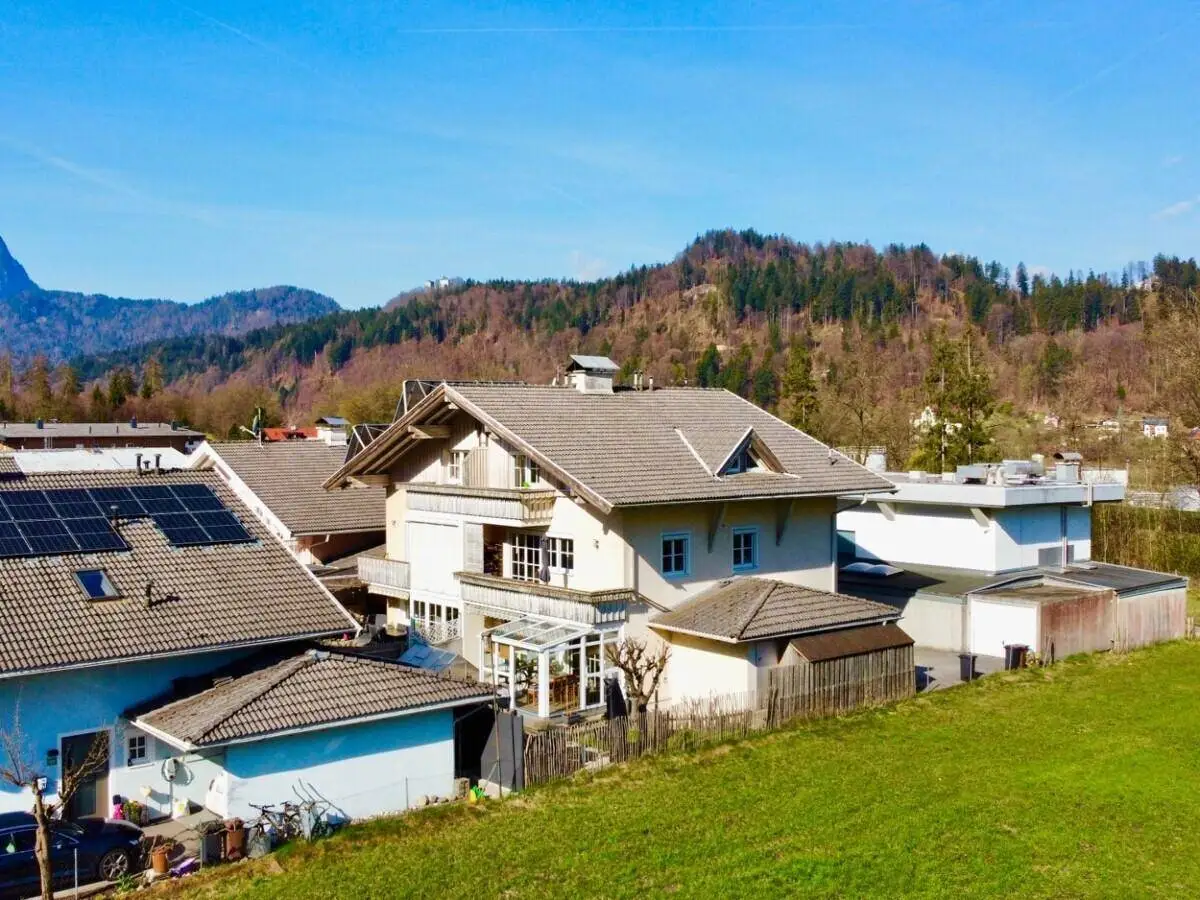Ansicht des Hauses mit Garten, Wintergarten und umliegender grüner Landschaft.