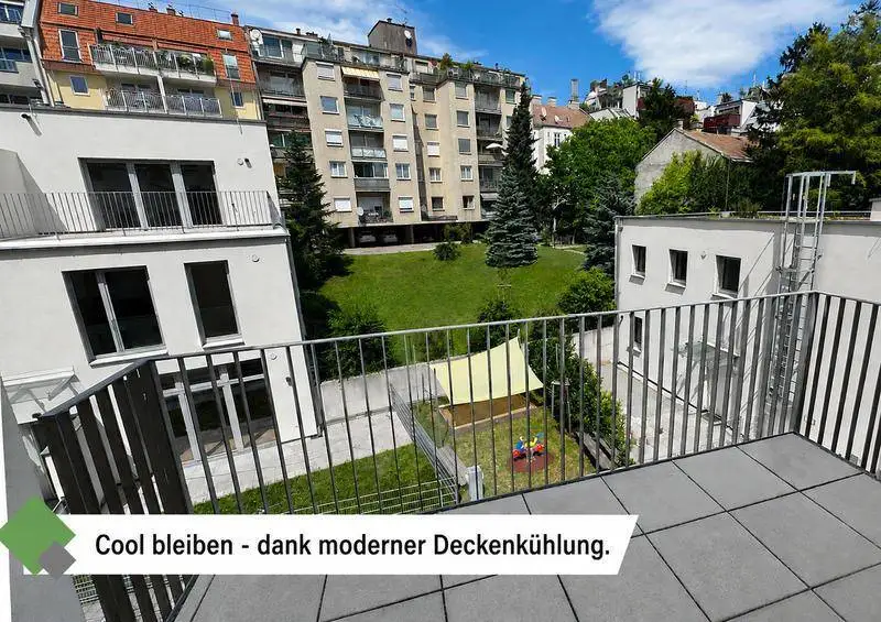 Blick von einem Balkon auf den begrünten Innenhof mit Spielbereich und weitere Wohngebäude.